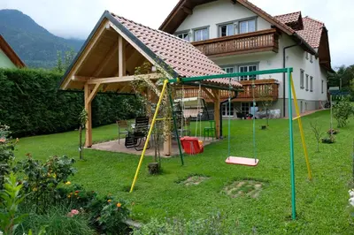 a house with a playground in the yard at Apartments Timjana in Bohinj