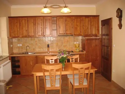 a kitchen with wooden cabinets and a table with flowers on it at Apartments Timjana in Bohinj