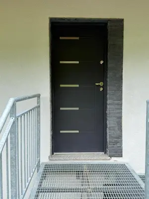 a black door on a building with a staircase at Apartma Klemenc in Bohinj
