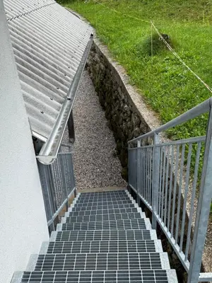 a stairway leading up to a building with a railing at Apartma Klemenc in Bohinj