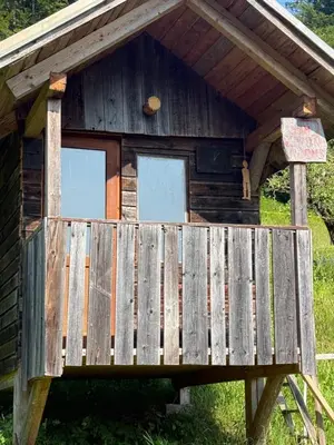 a wooden cabin with two windows on the front at Apartma Klemenc in Bohinj