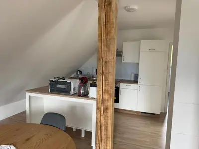 a kitchen with a counter with a microwave and a table at Apartma Klemenc in Bohinj