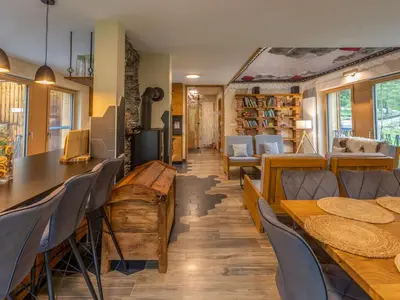 a room with wooden tables and chairs and a library at Villa Taja