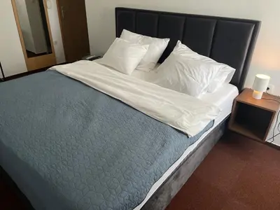 a large bed with white sheets and pillows on it at hotel Diana in Murska Sobota