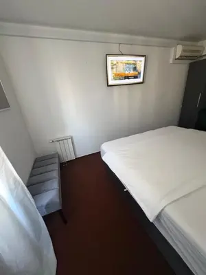 a small room with two beds and a picture on the wall at hotel Diana in Murska Sobota
