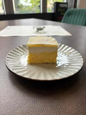 a piece of cake on a white plate on a table at hotel Diana in Murska Sobota