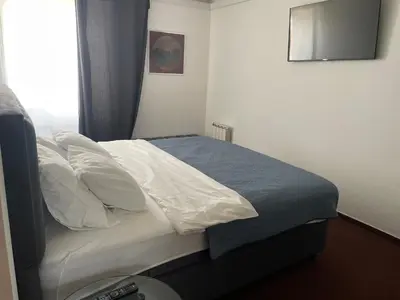 a bedroom with a bed with white sheets and pillows at hotel Diana in Murska Sobota