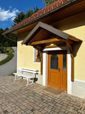 a wooden door and a bench in front of a building at The Little Fern Apartment in Rovte