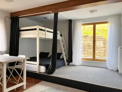 a bedroom with bunk beds with a desk and a window at The Little Fern Apartment in Rovte