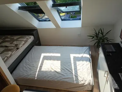 a bed in a room with two windows at Apartment Simon in Škofja Loka