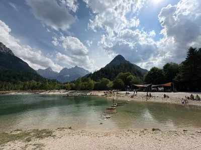 a group of people on a beach next to a river at Alpine Sun apartment in Kranjska Gora