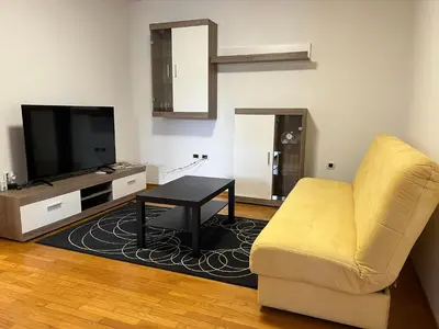 a living room with a yellow couch and a television at Apartma DaPDa in Spodnje Škofije