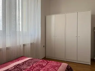 a bedroom with a bed and a large white cabinet at Apartma DaPDa in Spodnje Škofije