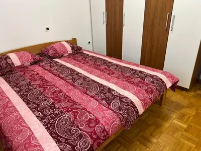 a bedroom with a bed with a pink comforter at Apartma DaPDa in Spodnje Škofije