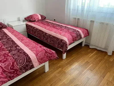 two beds in a room with wooden floors at Apartma DaPDa in Spodnje Škofije