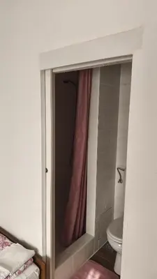 a bathroom with a shower with a pink shower curtain at Sobe Godina in Materija