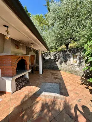 a patio with a brick fireplace on a house at Božič Residence in Vipava