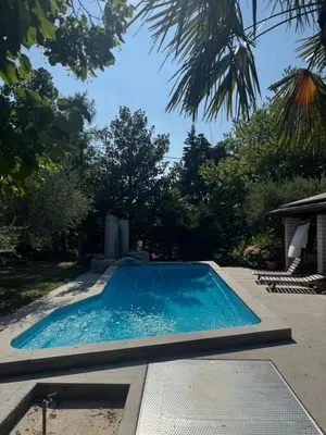 a swimming pool with blue water in a yard at Božič Residence in Vipava