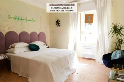 a bedroom with a large bed with a white blanket at Alma ART B&B in Dobrovo