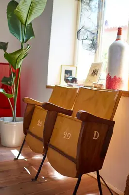 two wooden chairs sitting in a room with a plant at Alma ART B&B in Dobrovo