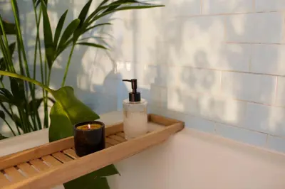 a wooden tray with a soap dispenser and a candle at Alma ART B&B in Dobrovo