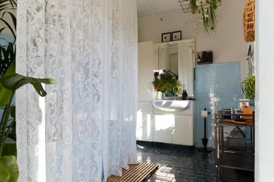 a bathroom with a white shower curtain and a sink at Alma ART B&B in Dobrovo