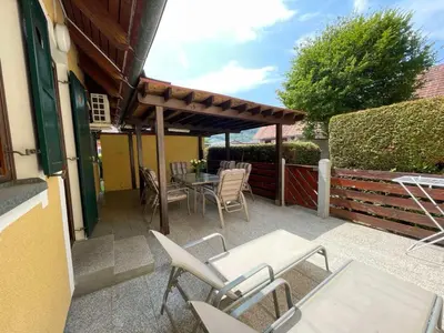 a patio with a table and chairs and a fence at Terme Čatež apartma Solist
