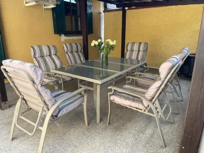 a table with chairs and a vase of flowers on it at Terme Čatež apartma Solist