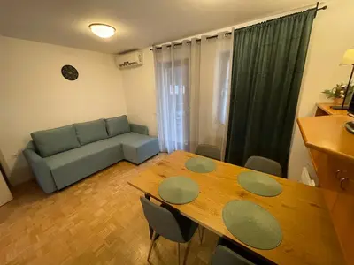 a living room with a table and a couch at Terme Čatež apartma Solist