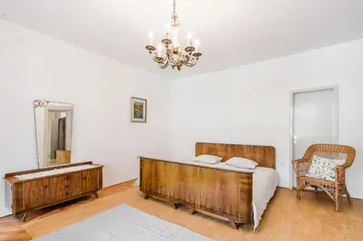 a bedroom with a bed and a table and a chandelier at Hiša Vuga in Tolmin