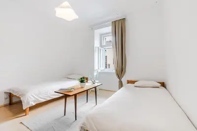 a bedroom with two beds and a table at Hiša Vuga in Tolmin