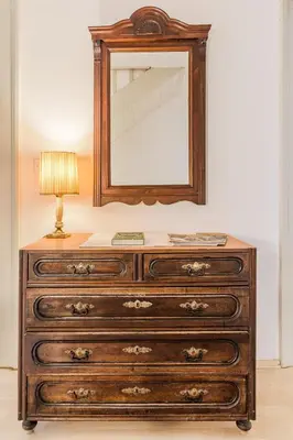 a dresser with a mirror and a lamp on top at Hiša Vuga in Tolmin