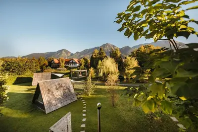a garden with a house and mountains in the background at Glamping Bizjak in Preddvor