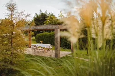 a table and chairs under a gazebo in a garden at Glamping Bizjak in Preddvor