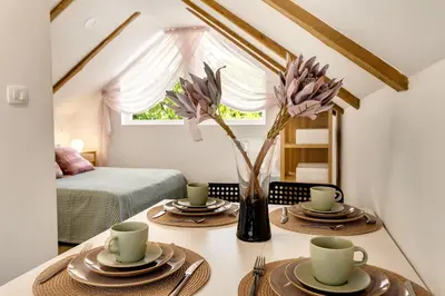 a room with a table with two cups and a vase with flowers at Mirola homes - rent in nature in Zagorje ob Savi