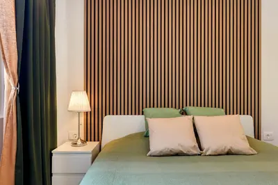 a bedroom with a bed with a wooden headboard at Mirola homes - rent in nature in Zagorje ob Savi