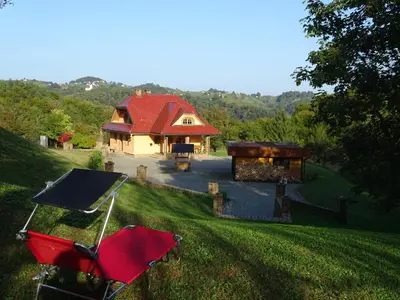a house with a red roof and a grill in the yard at Vila Gradisca in Gradišča