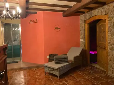 a living room with an orange wall and a chair at Vila Gradisca in Gradišča