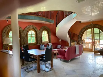 a room with a table and chairs and a spiral staircase at Vila Gradisca in Gradišča