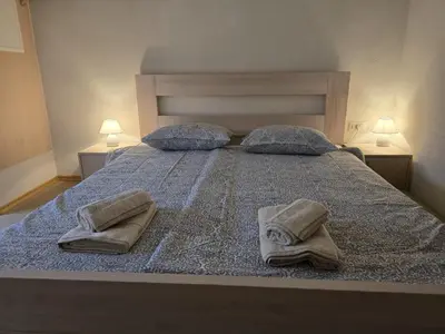 a bed with two towels and two lamps on it at Razor Vista Apartment in Tolmin