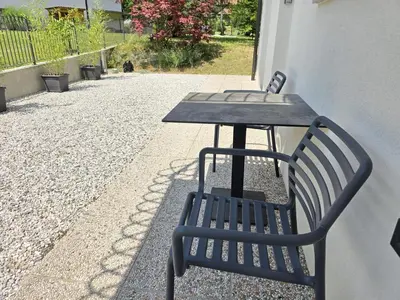 a table and chairs sitting next to a table and a table and sidx sidx sidx at Razor Vista Apartment in Tolmin