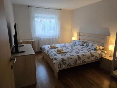 a bedroom with a bed and a television and a window at Razor Vista Apartment in Tolmin
