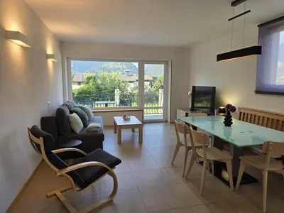 a living room with a table and a couch at Razor Vista Apartment in Tolmin