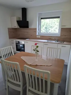 a kitchen with a table with a vase of flowers on it at Apartments Serafina in Tolmin
