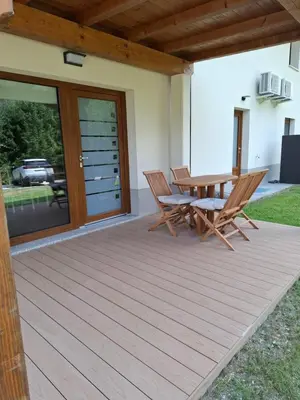 a wooden deck with two chairs and a table at Apartments Serafina in Tolmin