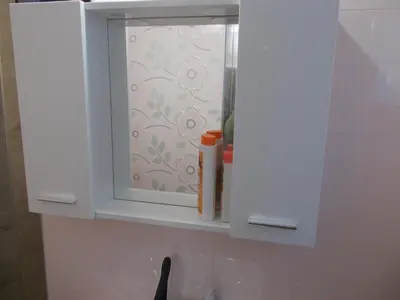 a white cabinet with a window over a sink at Apartma Prima in Podbočje