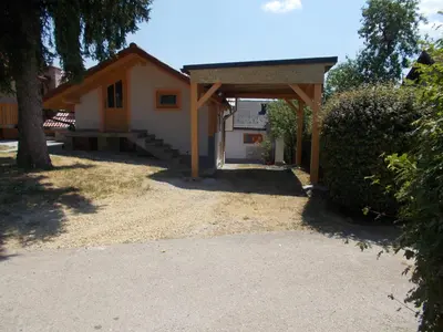 a small house with a porch and a garage at Apartma Prima in Podbočje