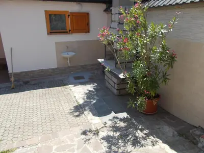 a patio with a bench and plants in front of a building at Apartma Prima in Podbočje
