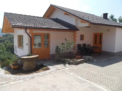 a small white house with a table in front of it at Apartma Prima in Podbočje