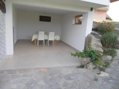 a patio with chairs and a table in a house at Apartma Prima in Podbočje